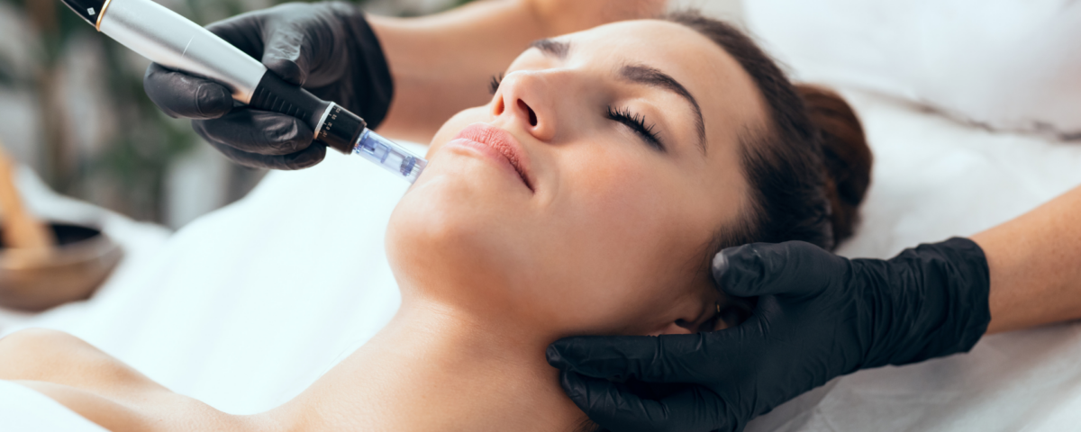 Women lies down with eyes closed while she gets a facial at a med spa