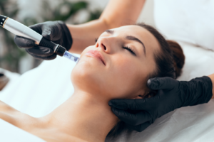 Women lies down with eyes closed while she gets a facial at a med spa