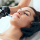 Women lies down with eyes closed while she gets a facial at a med spa